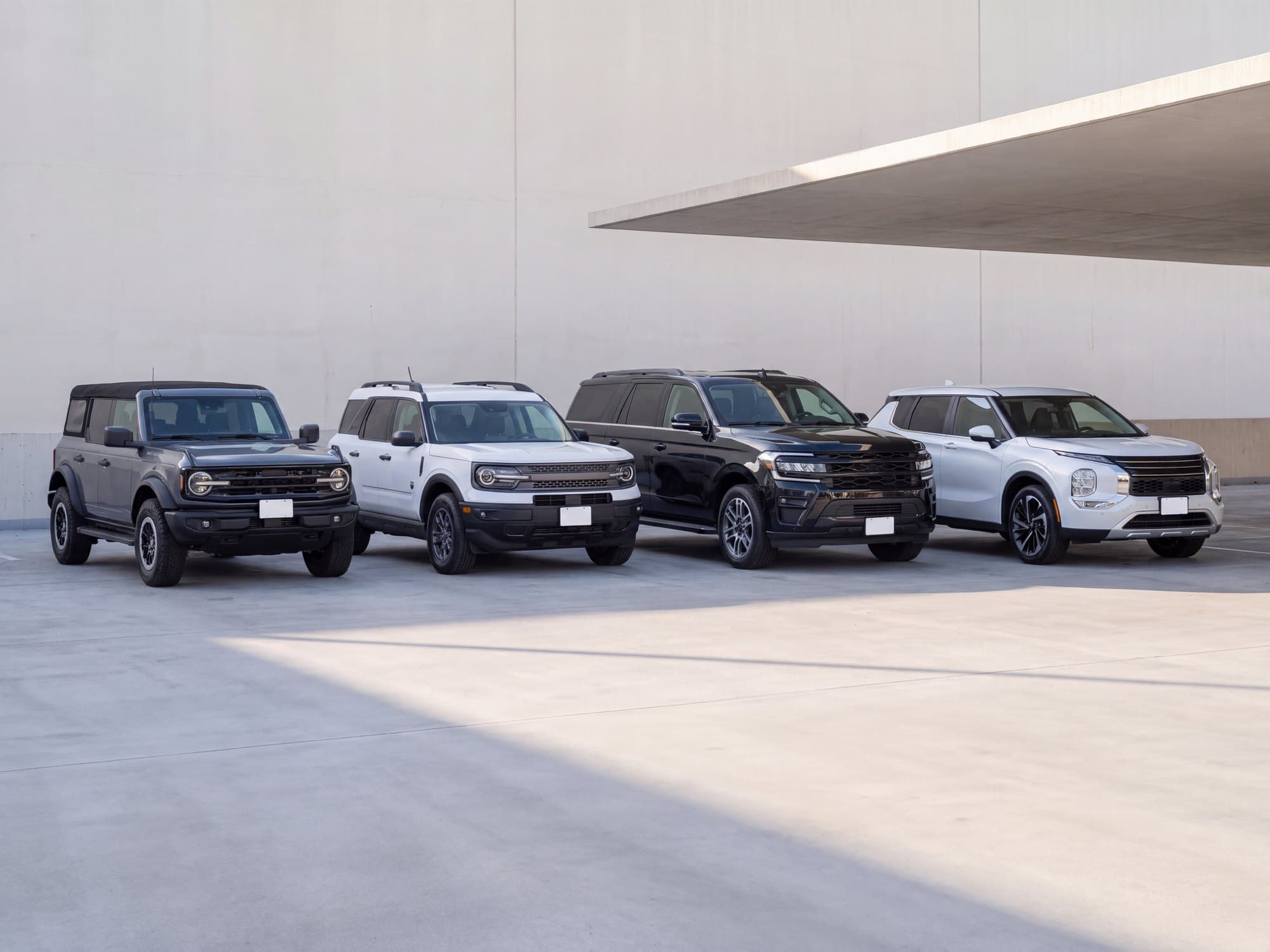 Four of Blue Diamond Vacations' cars lined up under a concrete canopy, ready for pickup.
